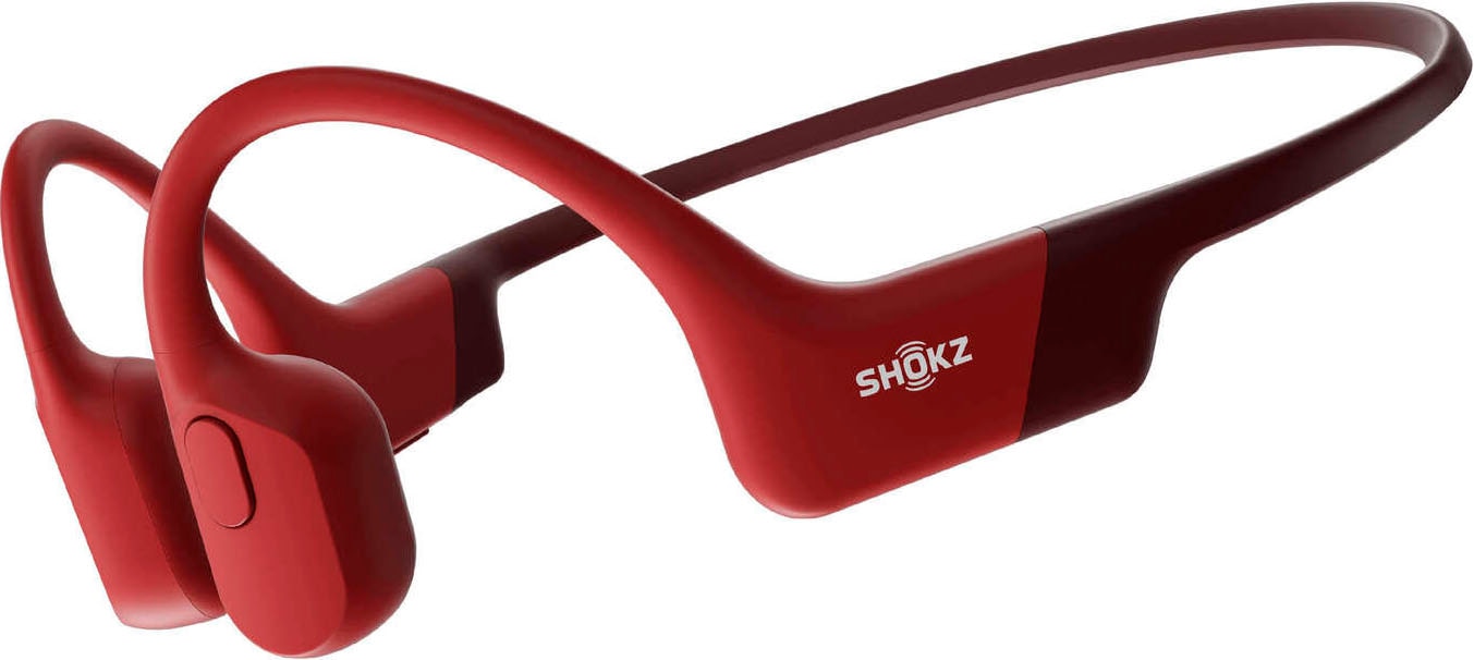 Red bone conduction headphones with an open-ear design, lightweight frame, and a sleek, flexible band, featuring the SHOKZ logo on the side.