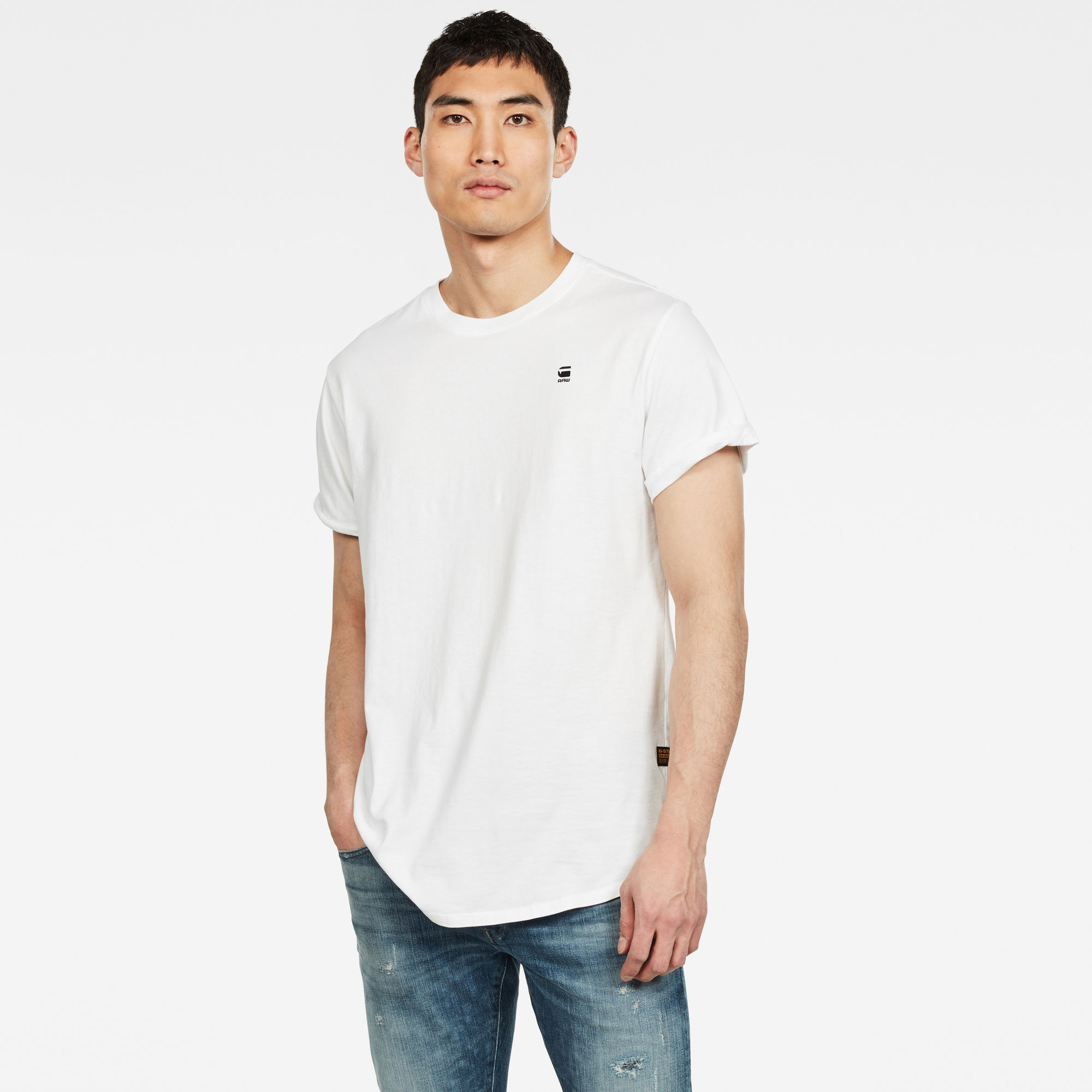 White short sleeve T-shirt by G-Star, featuring a crew neck, relaxed fit, and a small logo on the chest, paired with light blue denim jeans.