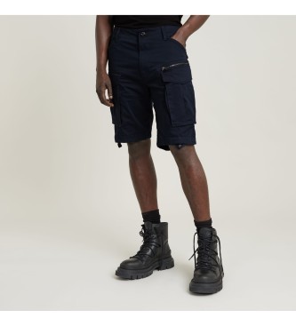 Navy blue cargo shorts with a zippered pocket, made from durable fabric, featuring a relaxed fit and side pockets, paired with black combat boots.