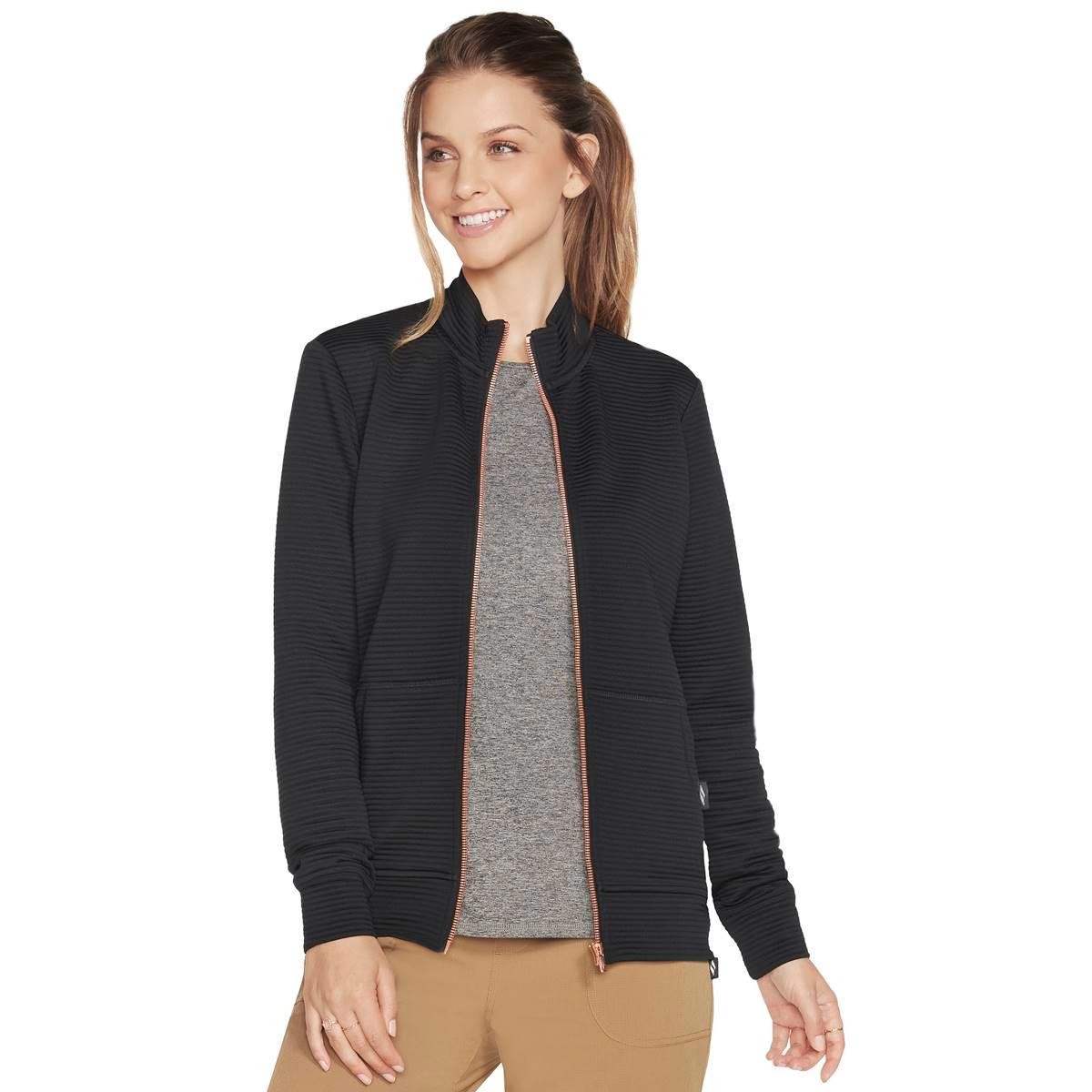 Black ribbed jacket with a zip front, high collar, and side pockets, featuring a cozy fit and stylish design, worn over a light gray top.