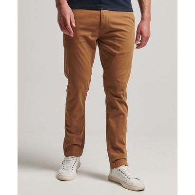 Slim fit chino trousers in a warm tan color, made from cotton, featuring a classic five-pocket design and worn with white sneakers.