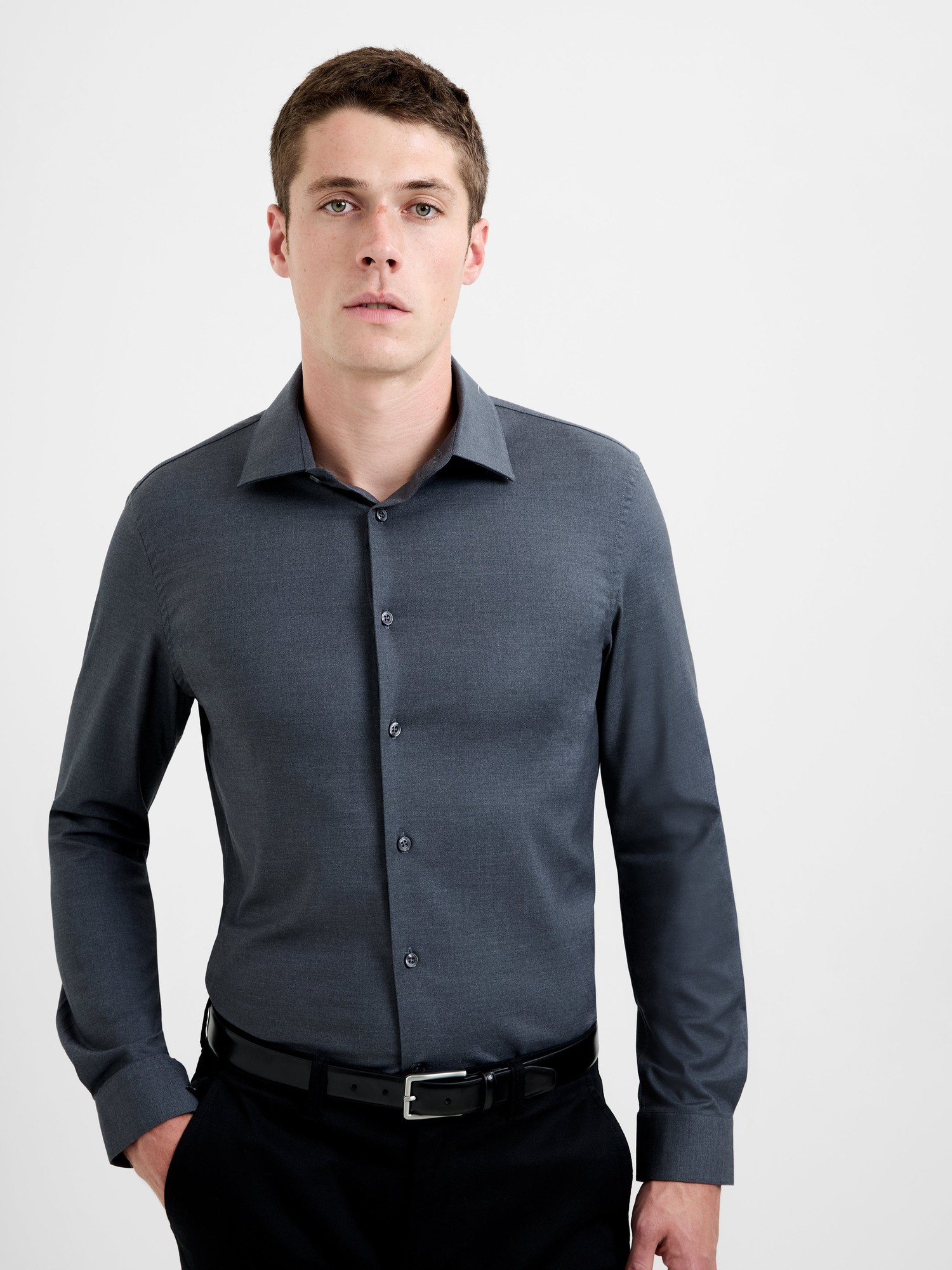Slim fit, regular collar shirt in steel melange wool blend, featuring a button-down front and long sleeves, paired with black trousers and a belt.