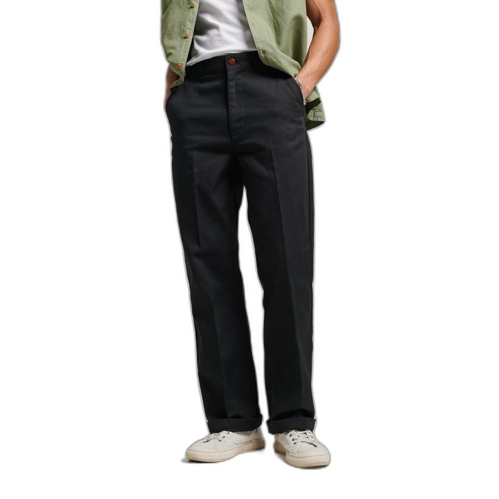 Straight cut chino pants in black by Superdry, featuring a classic design, front pockets, and a button closure, paired with a casual green shirt and white sneakers.