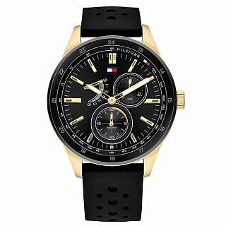 Men's Tommy Hilfiger Austin watch featuring a 44mm black dial, gold-tone case, and black silicone strap, with multi-function sub-dials and bold hour markers.