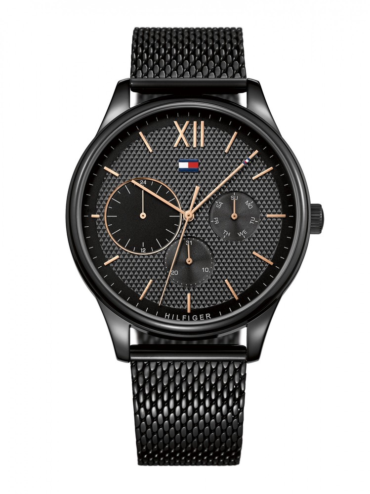 Black multi-function watch with a textured black dial, rose gold accents, and a mesh strap, featuring three sub-dials and the Tommy Hilfiger logo.