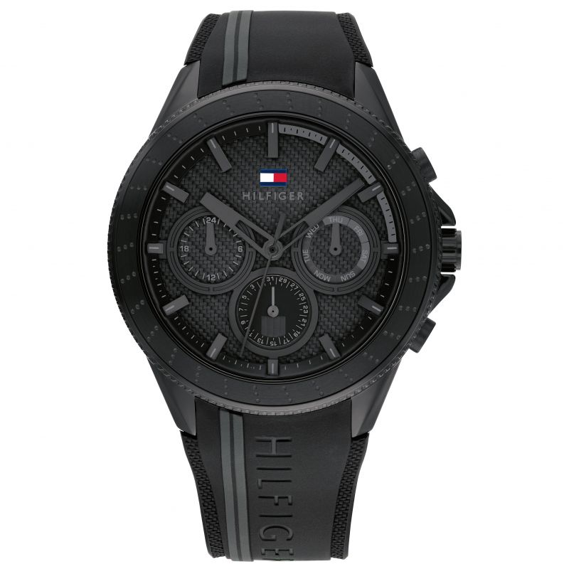 Men's Tommy Hilfiger Aiden watch featuring a 44mm black dial, black silicone strap, and multifunctional chronograph with textured detailing and the brand's logo.