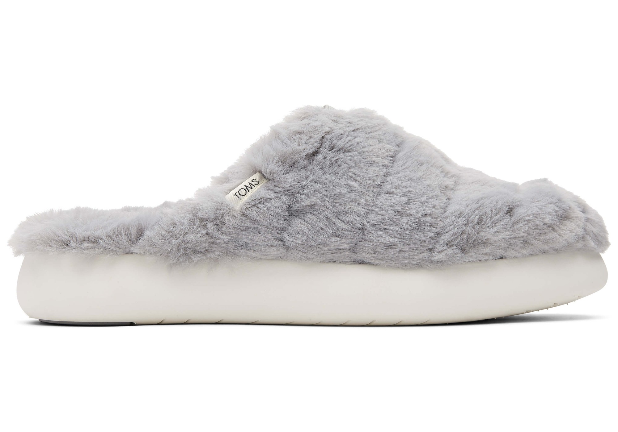 Mid grey faux fur mules by TOMS featuring a soft, textured upper, a cushioned white sole, and a small TOMS logo tag on the side.