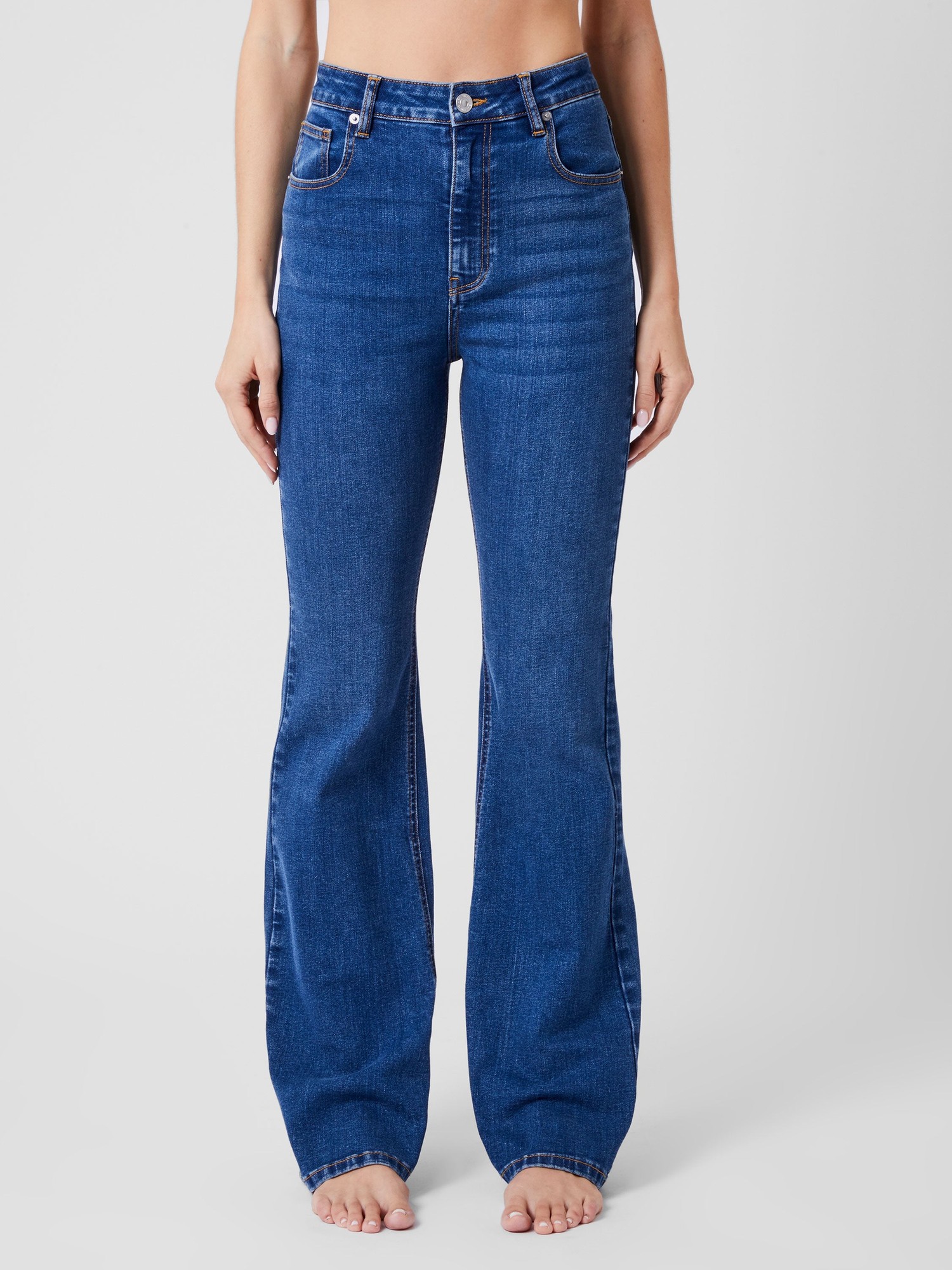Mid-wash denim flared jeans with a high waist, featuring five pockets, belt loops, and a slight stretch for comfort, styled with a fitted silhouette.