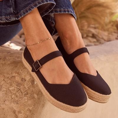 Black heavy canvas Mary Jane espadrilles with a strap and a jute-wrapped sole, worn with denim, showcasing a stylish and casual design.