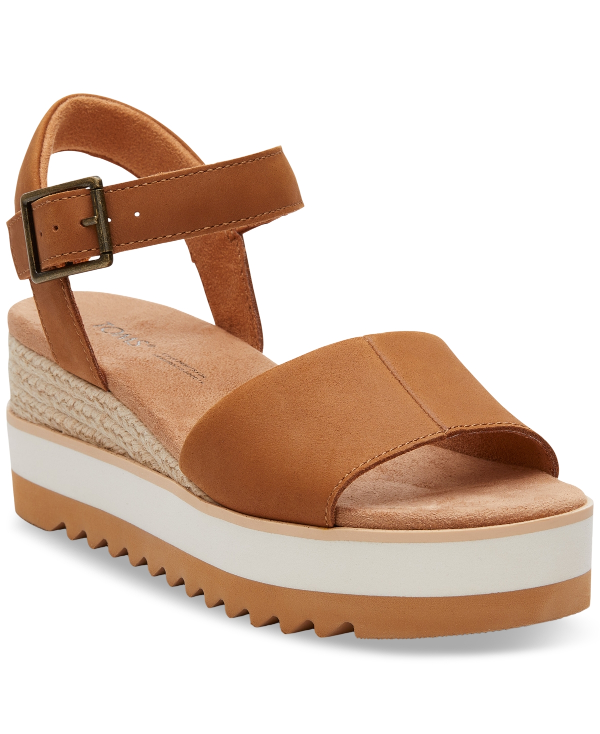 Brown leather wedge sandal with a wide strap, adjustable ankle buckle, and a textured espadrille platform featuring a white midsole and a ridged rubber outsole.