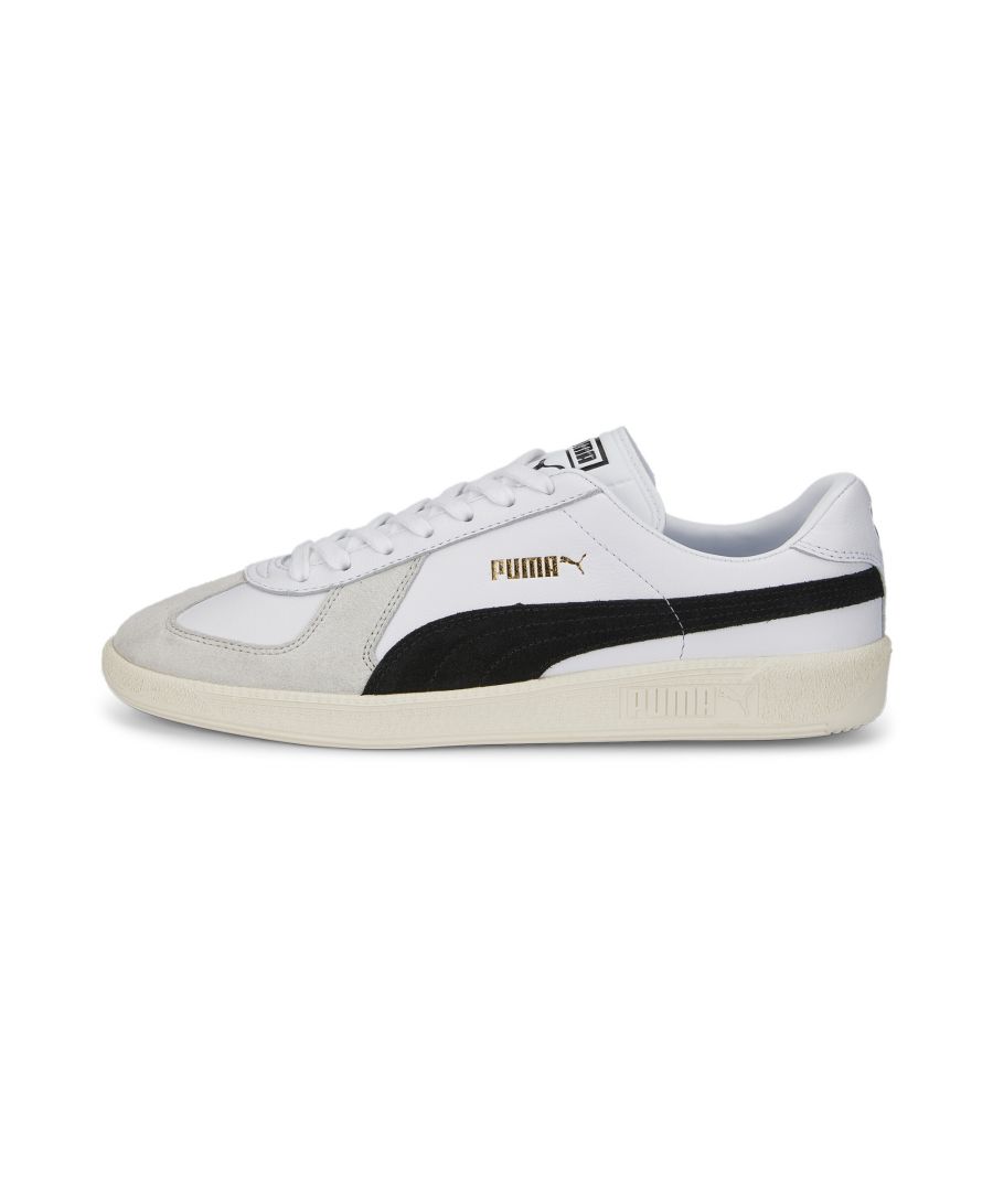 White leather trainers with black suede accents, featuring a gold Puma logo, lace-up design, and a textured rubber sole.
