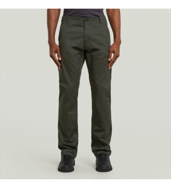 Olive green G-Star Mosa Chino trousers made from durable cotton, featuring a straight fit, belt loops, and front pockets, styled with a simple black shirt and black shoes.