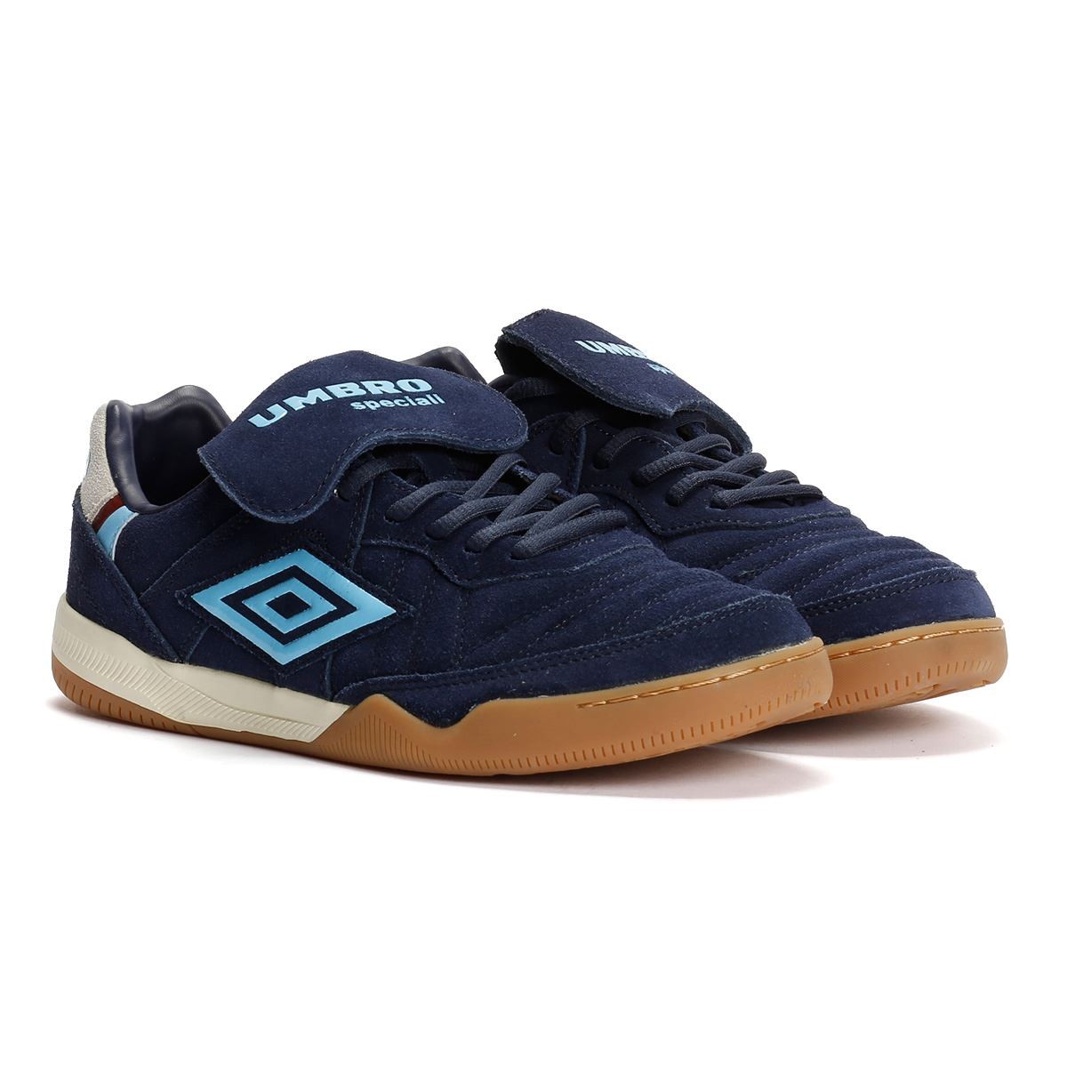 Dark navy suede trainers with vista blue accents, featuring a gum rubber sole, lace-up closure, and a Velcro strap on the tongue, branded with Umbro logo.