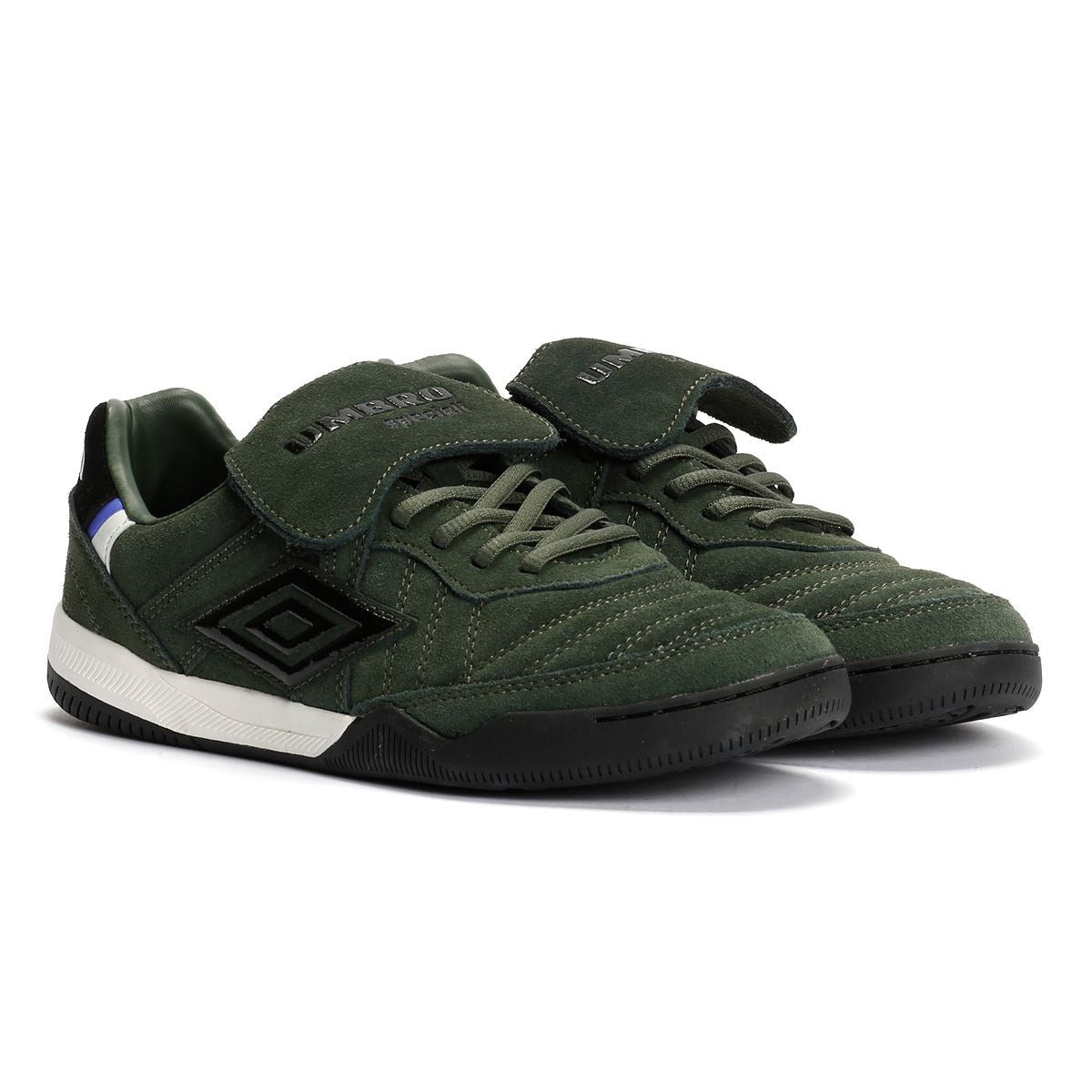 Black suede trainers with a textured finish, featuring a padded tongue, velcro strap, and a white sole with a black rubber outsole, branded with the Umbro logo.