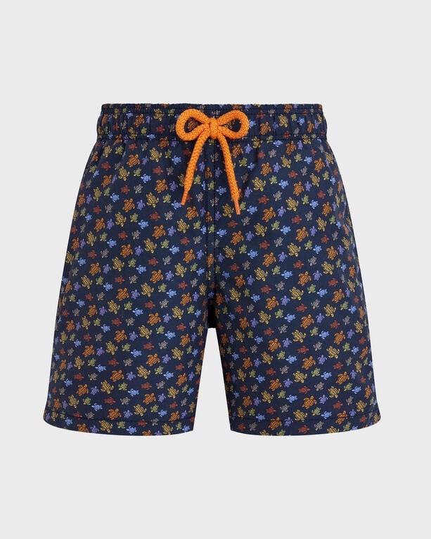 Boys' swim shorts in navy blue featuring a vibrant turtle print in orange and yellow, with an elastic waistband and contrasting orange drawstring, size 4.