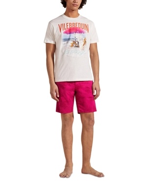 White cotton T-shirt featuring a colorful beach scene graphic and "Vilebrequin" text, paired with bright pink shorts, model stands barefoot. Size XL.
