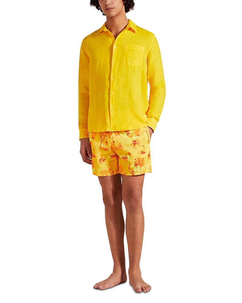 Bright yellow linen classic fit shirt with a button-down front and a chest pocket, paired with patterned swim shorts, worn by a model standing barefoot.