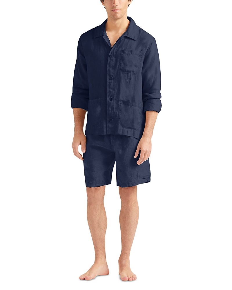 Navy blue linen overshirt with a relaxed fit, button-down front, and chest pocket, paired with matching shorts, worn by a model standing barefoot.