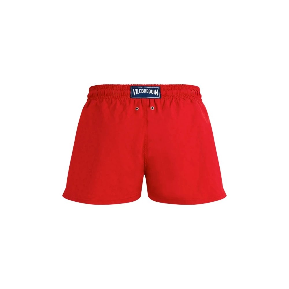 Red jacquard swim shorts featuring a turtle pattern, elastic waistband with drawstring, and Vilebrequin branding on the front, size M.