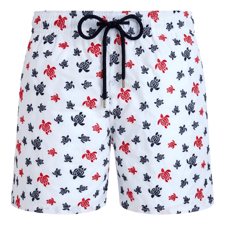 White swim shorts featuring an embroidered pattern of red and navy turtles, with a drawstring waist and a lightweight material, labeled as limited edition by Vilebrequin in size L.