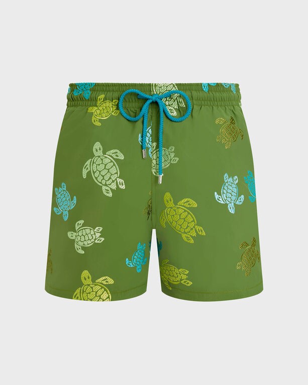 Green swim shorts featuring multicolored embroidered turtle designs, adjustable blue drawstring, and a lightweight material, available in size XL as part of a limited edition collection.