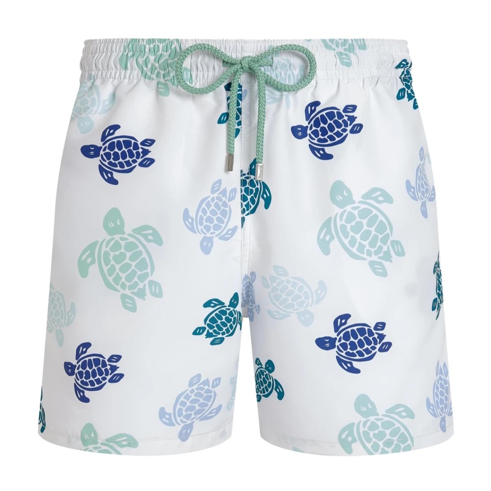 White swim shorts featuring a colorful turtle print in blue and green shades, with an elastic waistband and a drawstring for adjustable fit, size XXL.