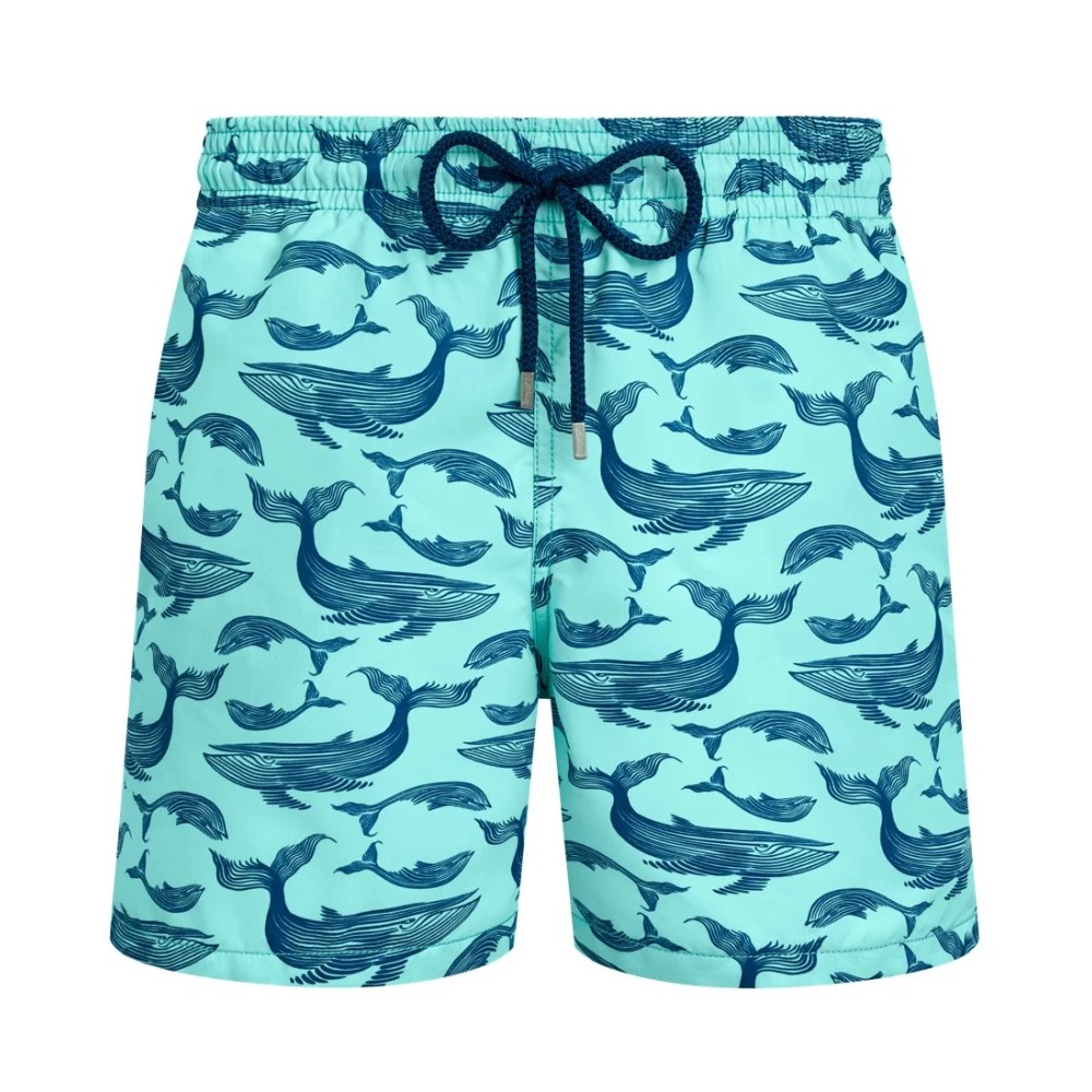 Light blue swim shorts featuring a marine whale print in dark blue, made from quick-drying material with an elastic waistband and drawstring for a secure fit.
