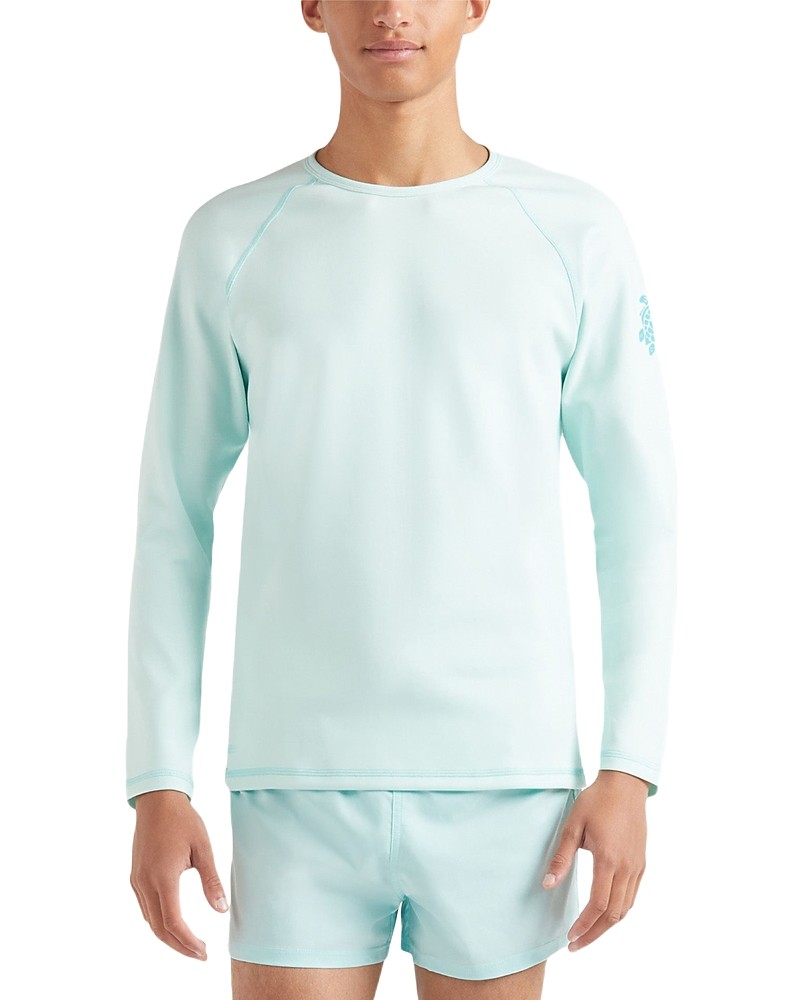 Light blue long sleeve rashguard made of stretchy material, featuring a crew neck and a subtle logo on the left sleeve, paired with matching swim shorts.