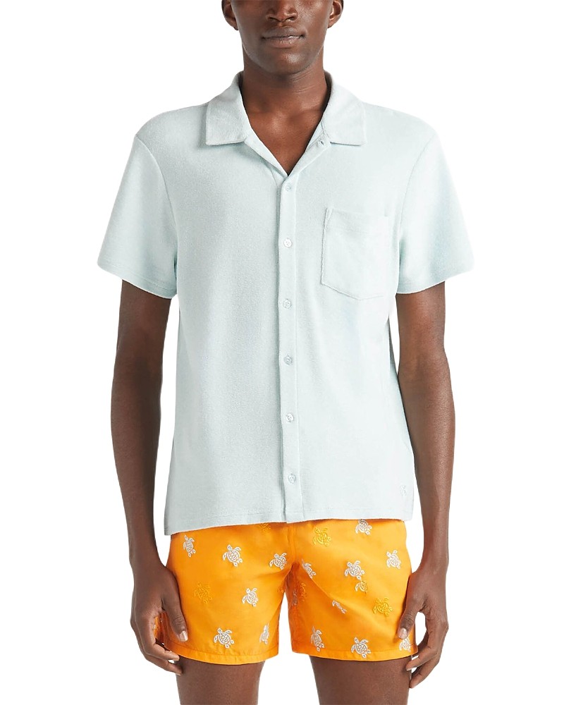 Light blue terry cloth bowling shirt with a button-up front, short sleeves, and a chest pocket, paired with bright orange shorts featuring white turtle patterns.