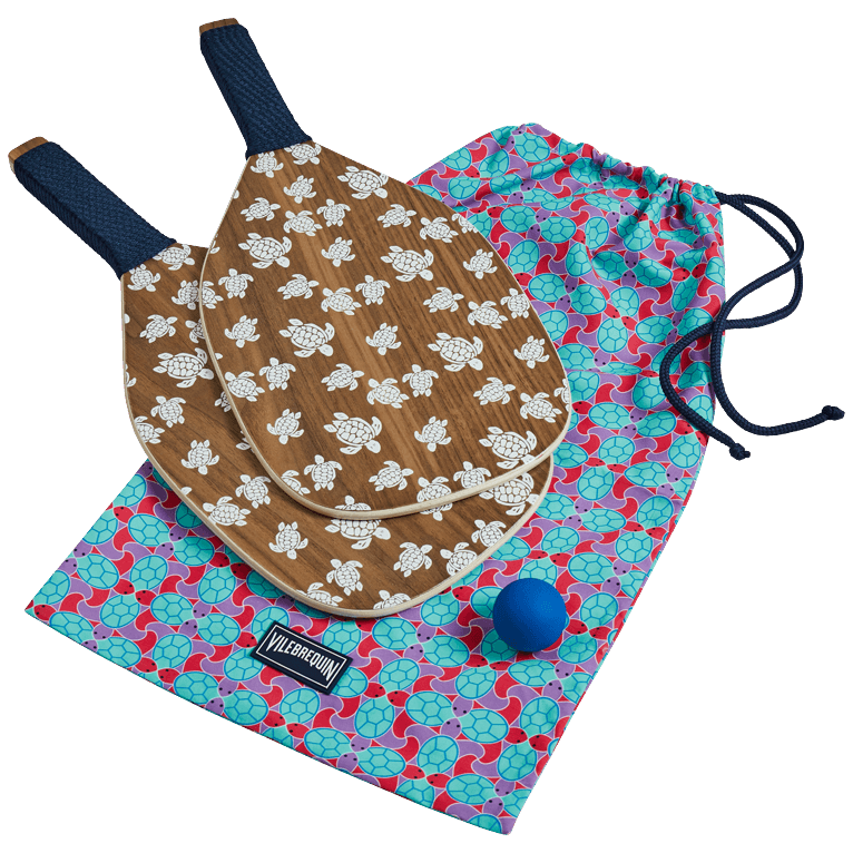 Wooden beach paddles with turtle designs, accompanied by a blue ball and a colorful drawstring bag featuring a vibrant floral pattern.