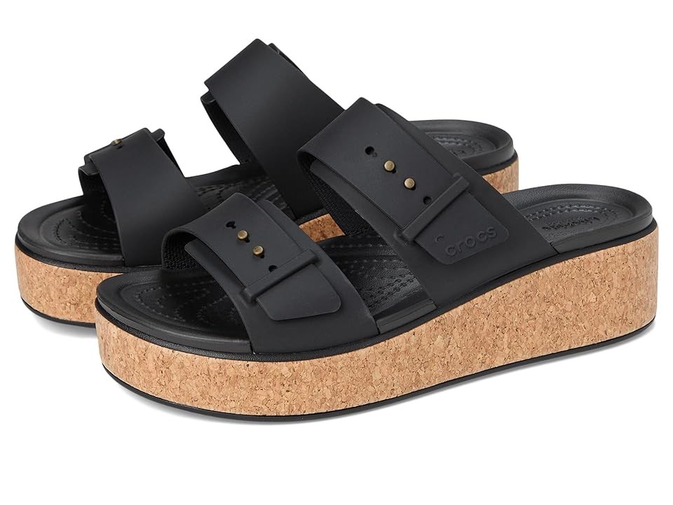 Black low wedge sandals with cork platform, featuring two wide straps with buckle details and a textured footbed for comfort.