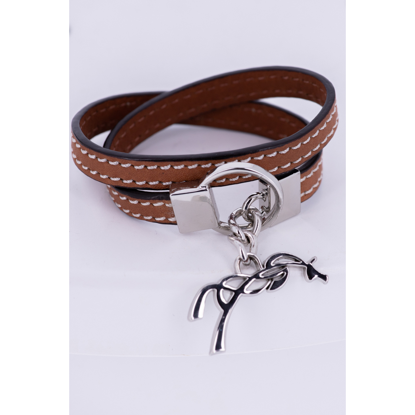 Brown leather bracelet with a double wrap design, featuring white stitching and a silver-toned clasp, adorned with a silver horse charm.