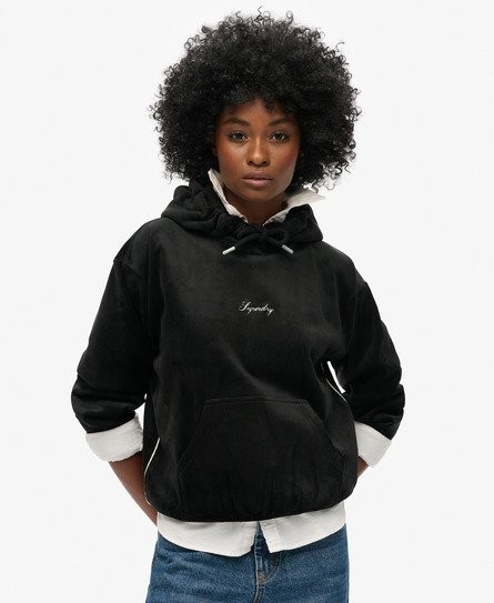 Black oversized velvet hoodie featuring a drawstring hood, front pocket, and embroidered "Superdry" logo, styled with a white shirt underneath.