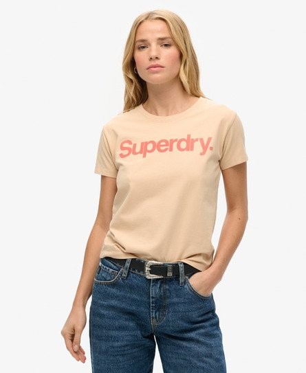 Beige fitted T-shirt featuring a prominent coral "Superdry." logo, made from soft cotton, paired with high-waisted blue jeans for a casual look. Size 4.