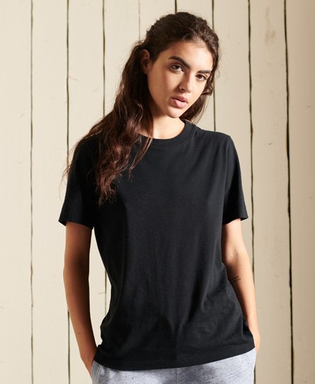 Black women's organic cotton T-shirt from Superdry, featuring a classic crew neckline and short sleeves, styled casually with a relaxed fit against a wooden background.