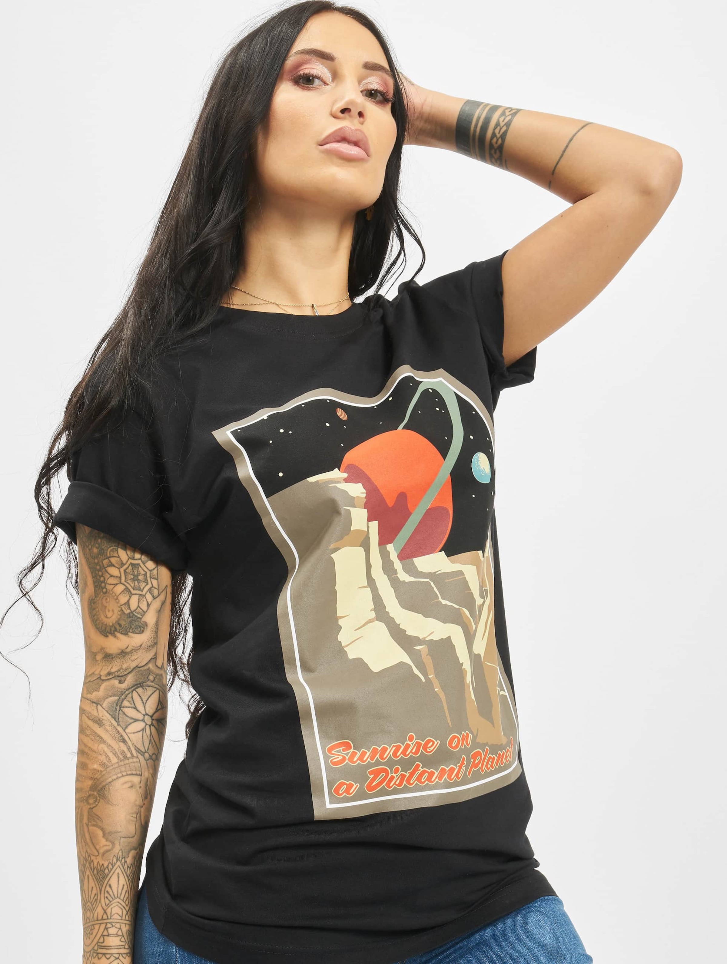 Black women's T-shirt featuring a colorful graphic of a planet and mountains, with the text "Sunrise on a Distant Planet," made from soft cotton material.