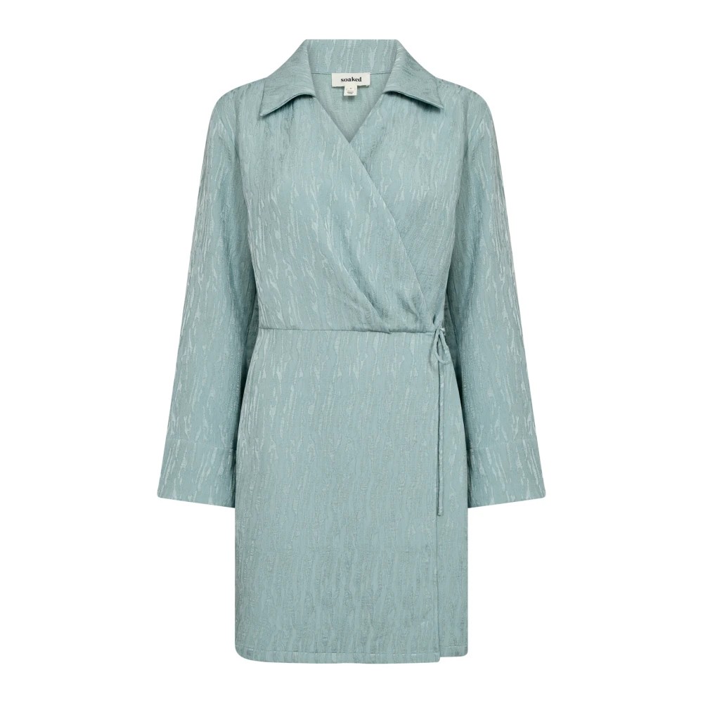 Light blue wrap dress with a textured finish, featuring long sleeves, a collar, and a tie waist, designed by Soaked in Luxury.