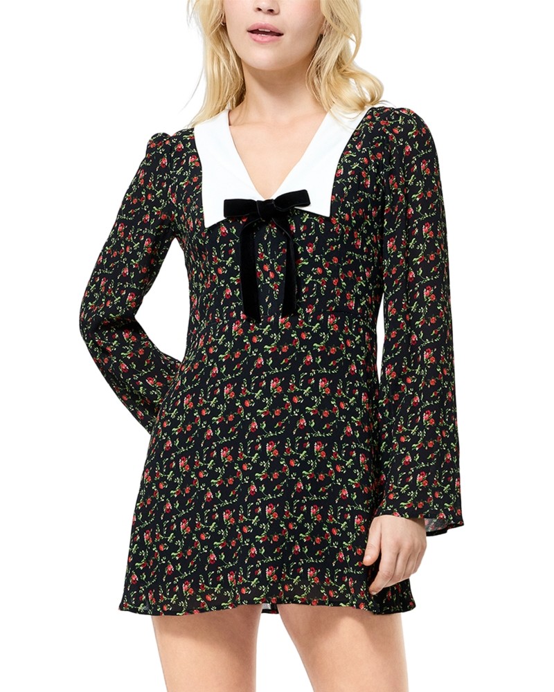 Black mini dress with a white crepe collar, long sleeves, and a bow detail at the neckline, featuring a floral print in red and green.