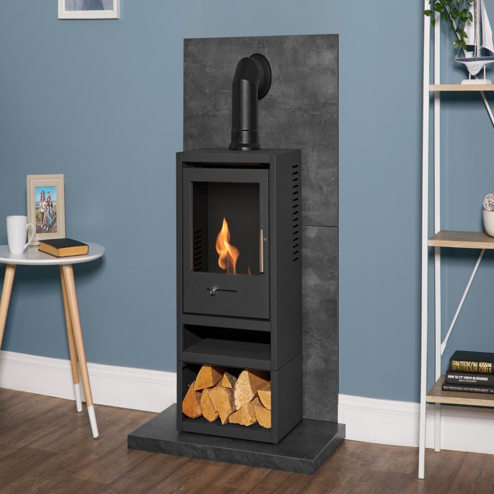 Slate Venetian plaster-effect tile and hearth set featuring a black OKO S1 stove with a glass front, log storage beneath, and an angled pipe, against a blue wall.