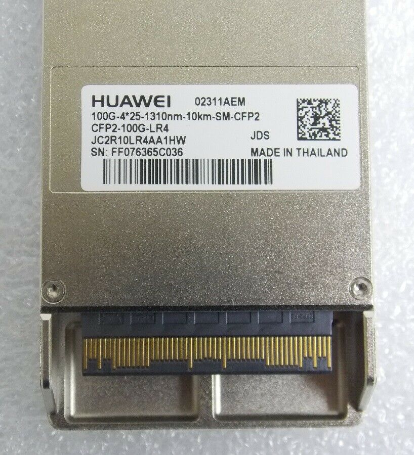 Huawei 02311AEM Comp TAA CFP2 LC transceiver in metallic silver with a barcode label, featuring a gold connector interface and detailed specifications printed on the side.