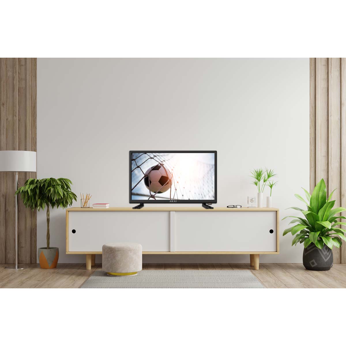 24" HD LED Android Smart TV on a light wooden TV stand, displaying a soccer ball, surrounded by a potted plant and a lamp in a modern, minimalist living room setting.