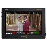 Blackmagic Design HYPERD/AVIDA12/7HDR Broadcast Monitor features a 7-inch display with HDR capabilities, showcasing a couple in a forest setting, framed in a sleek black casing.