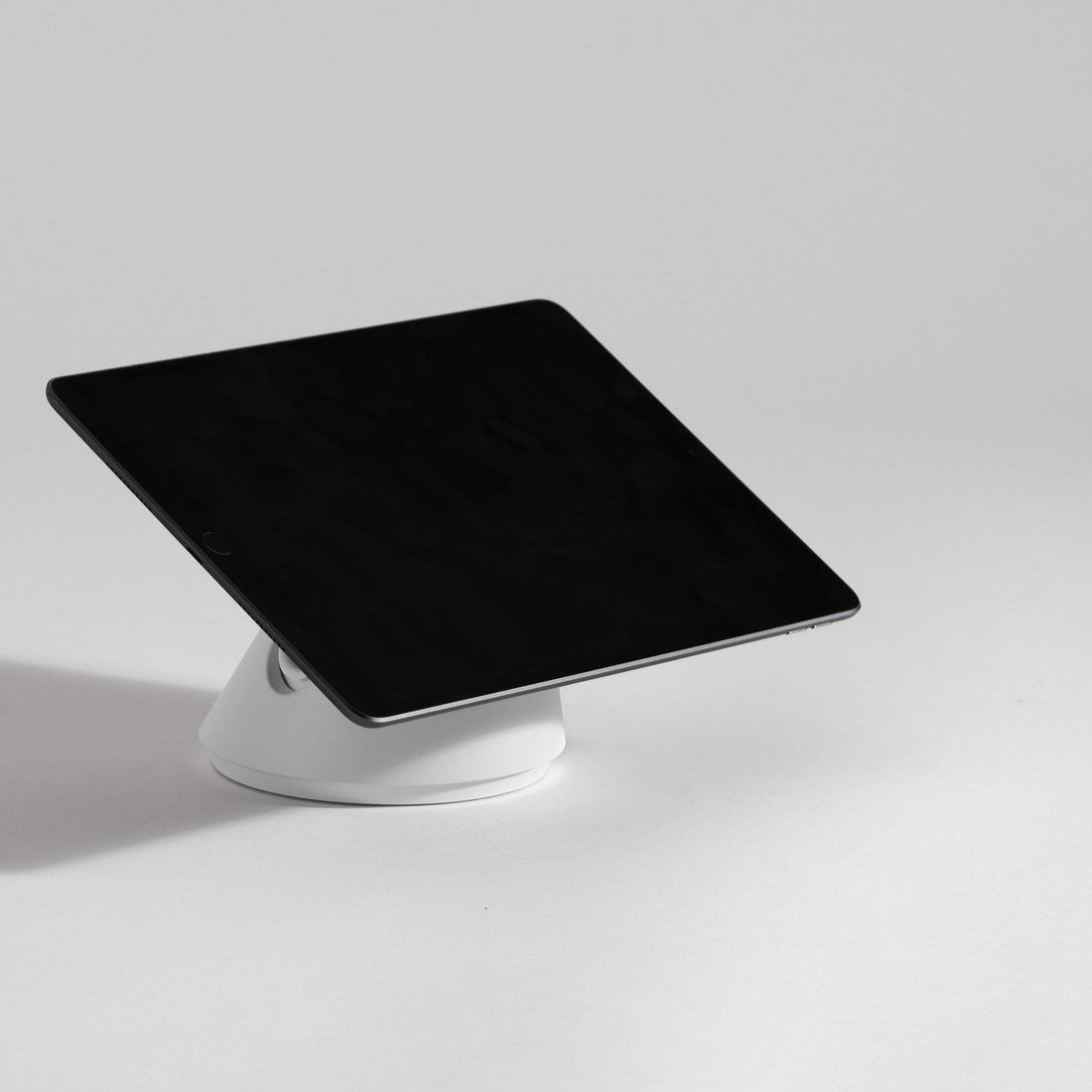 Secure tablet stand in dark grey with a sleek, modern design, featuring a sturdy base and adjustable angle for optimal viewing.