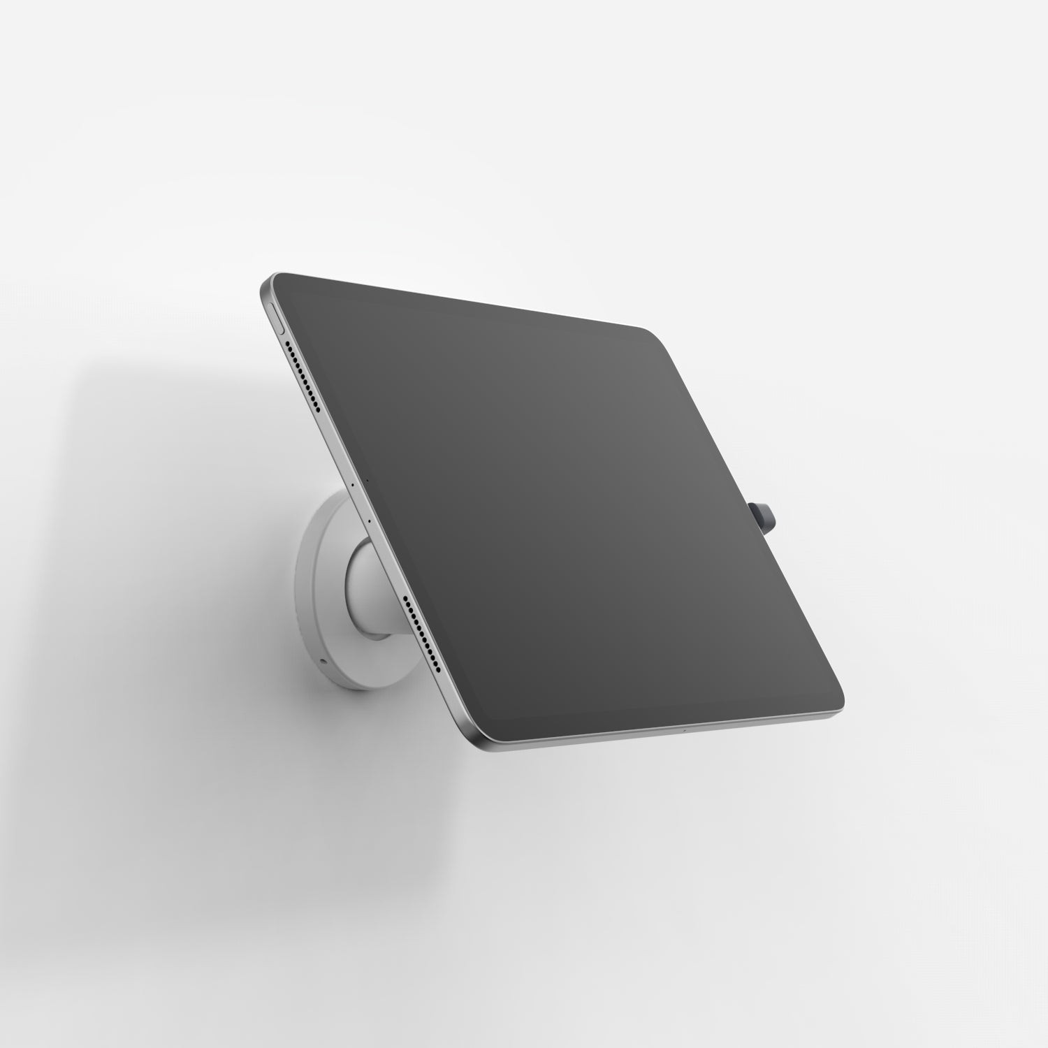 White Bouncepad Core Wallmount securely holds a USB-C tablet at an angle, featuring a sleek design with a circular mount and minimalistic aesthetic.