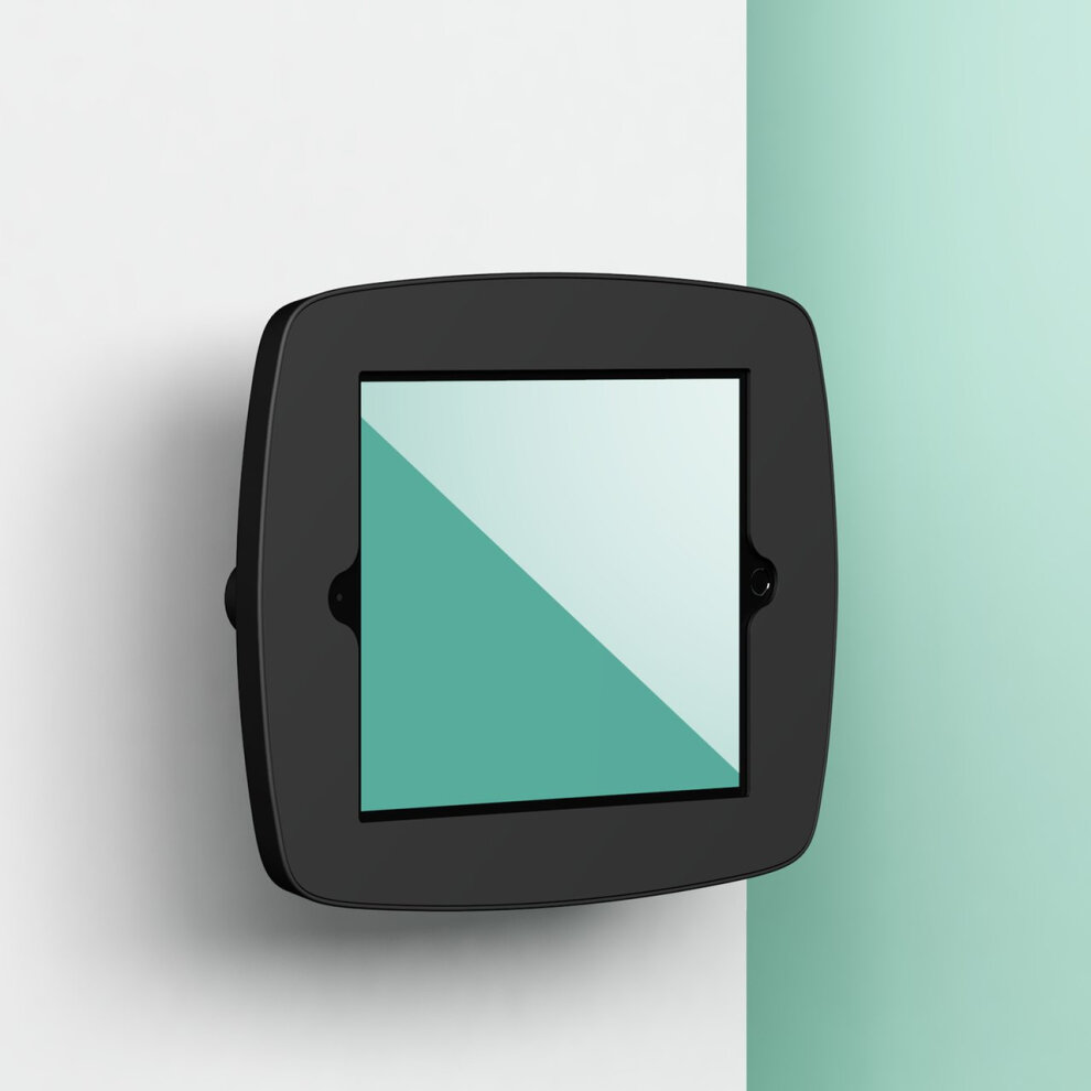 Black Bouncepad VESA mount for Apple iPad 6th Gen 9.7 (2018), featuring a covered front and a sleek, modern design, mounted on a wall with a mint green background.