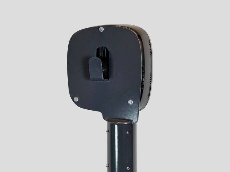 Black charging station mounted on a sleek pole, featuring a compact design with a prominent connector holder and ventilation slots for efficient cooling.