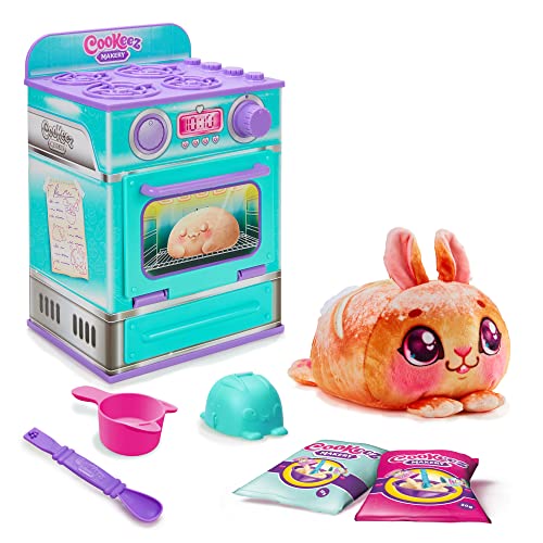 Colorful Cookeez Makery oven playset in teal and pink, featuring an oven with dials, a plush bread toy shaped like a bunny, measuring cup, spatula, and cookie packets.