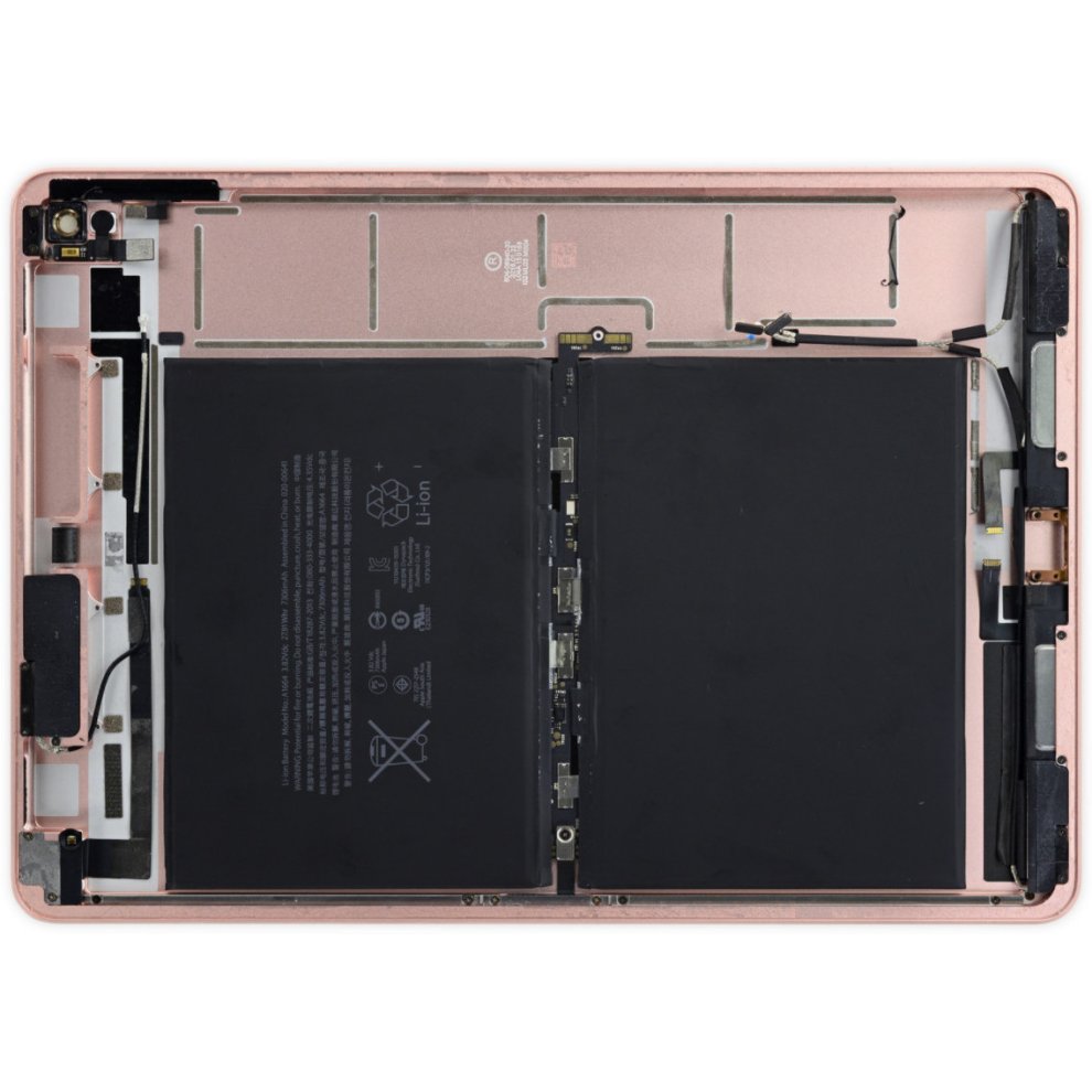 CoreParts MBXAP-BA0025 laptop battery in black, featuring a rectangular shape with printed specifications, connectors, and wiring visible on a metallic pink laptop interior.