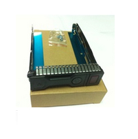 Black computer case part with a blue metallic interior, featuring a vented design and a small bag of screws included, resting on a brown cardboard base.