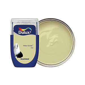 Dulux Colour Tester in Melon Sorbet, 30ML, features a light yellow-green paint in a clear container with a silver lid, showcasing the smooth texture of the paint.